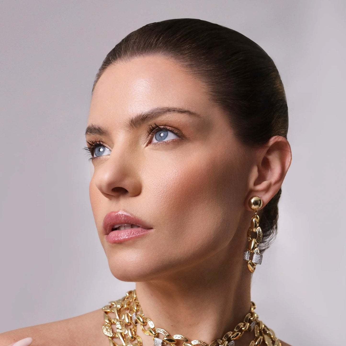 Modelo usando Aros Arona dorados semilujo con zirconia pavé, estilo elegante italiano – Trovare Chile
