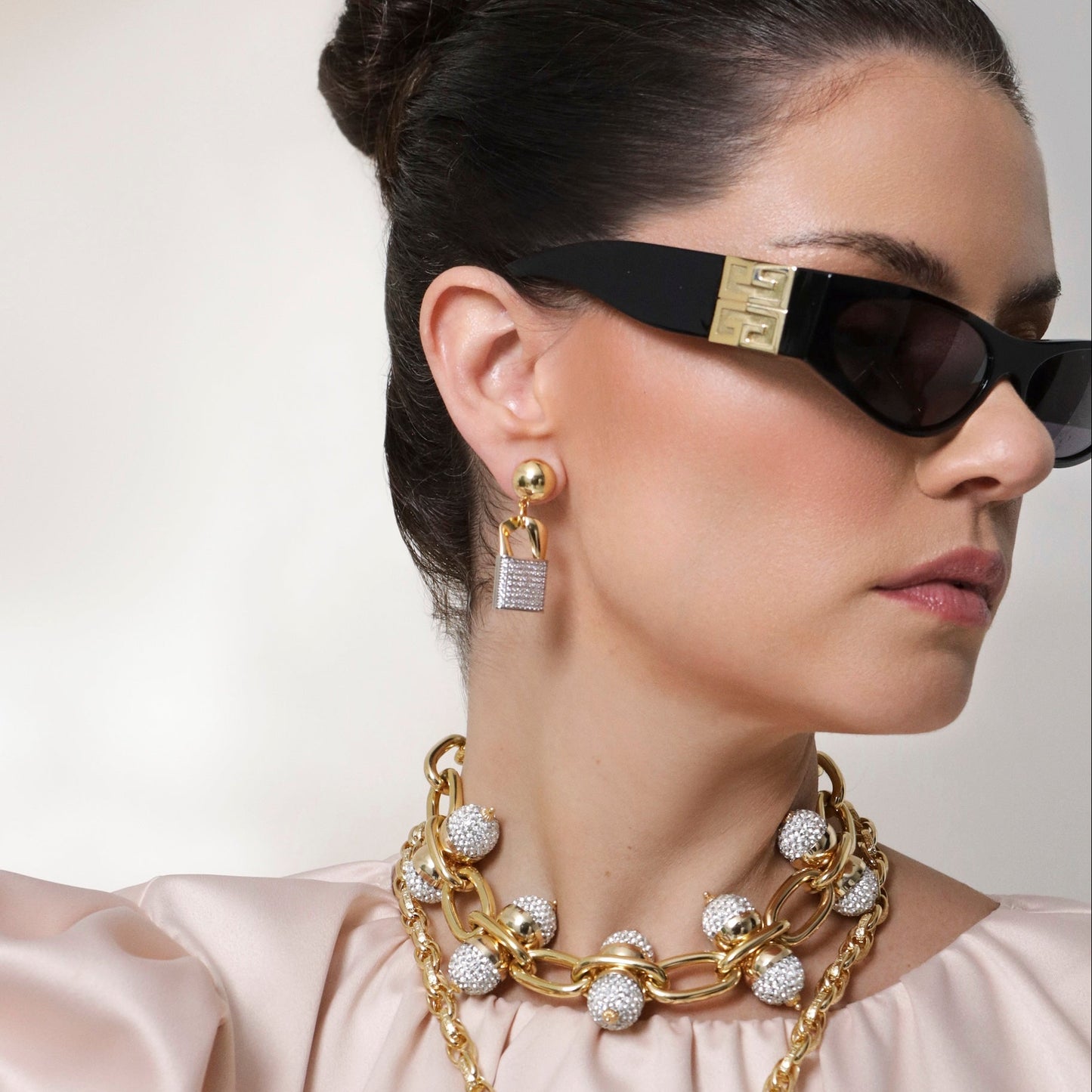 mujer usando look chic con joyas bañadas en oro y cristales