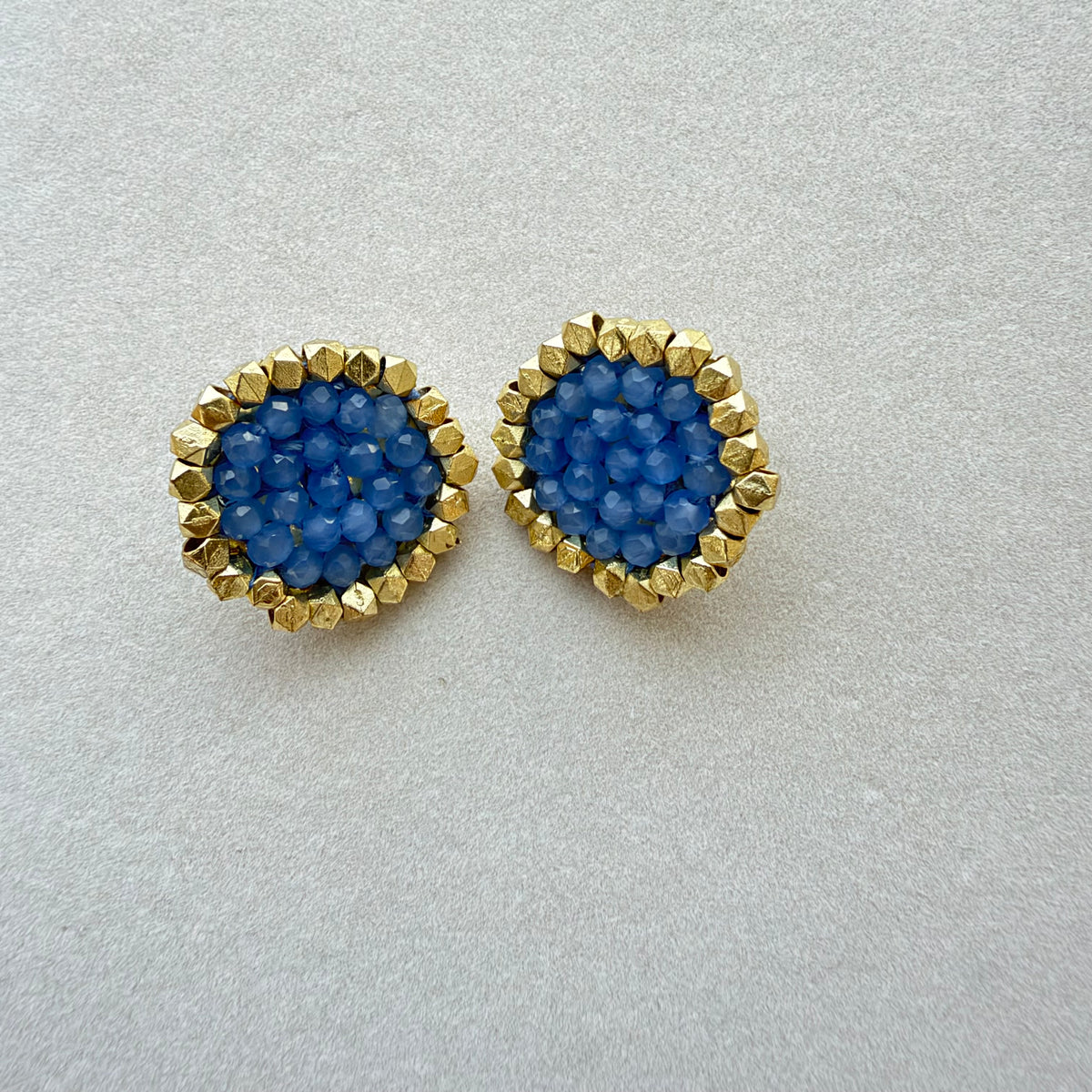 Par de Aros Trisha con cuentas facetadas azules y borde dorado