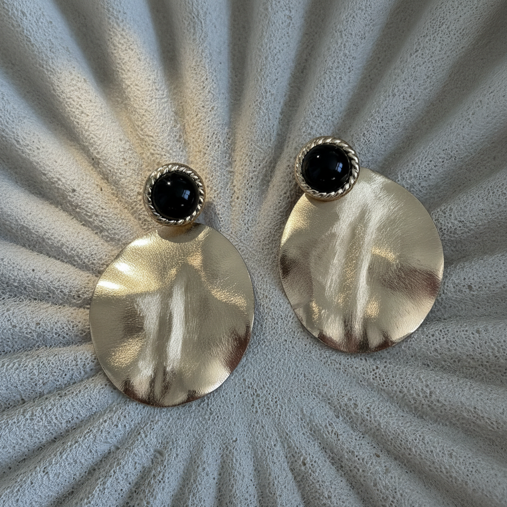 Aros Aimee con baño de oro de 18 quilates y resina negra. Diseño elegante, liviano e ideal para eventos y uso diario.