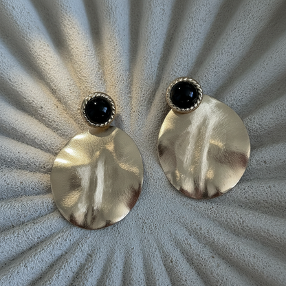 Aros Aimee con baño de oro de 18 quilates y resina negra. Diseño elegante, liviano e ideal para eventos y uso diario.