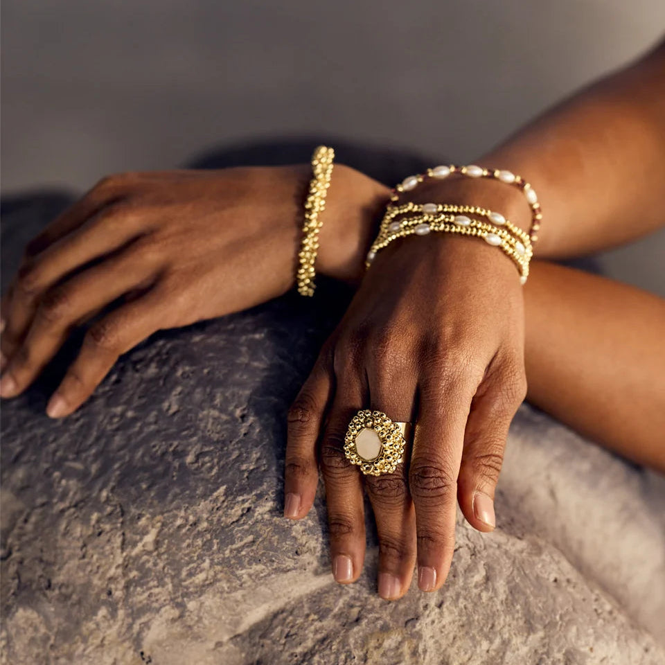 manos de mujer mostrando forma de usar la pulsera aahwini perlas