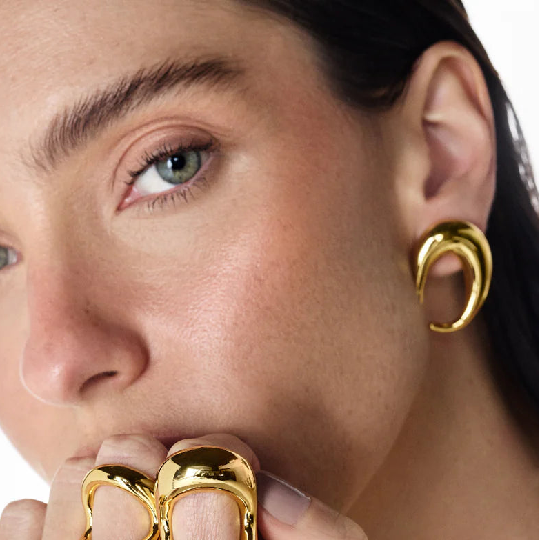 mujer con aros baño de oro amarillo 18 quilates