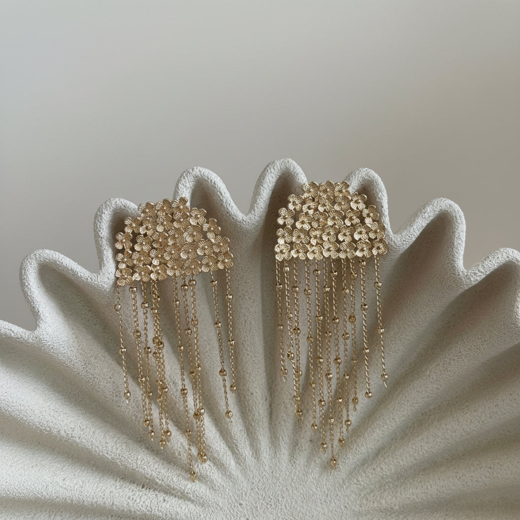 Aros Isadora con baño de oro de 18 quilates, diseño floral y delicadas cadenas colgantes. Hechos en Brasil, elegantes y livianos.