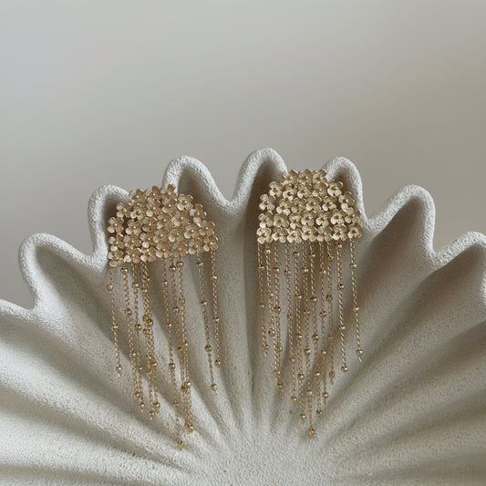 Aros Isadora con baño de oro de 18 quilates, diseño floral y delicadas cadenas colgantes. Hechos en Brasil, elegantes y livianos.