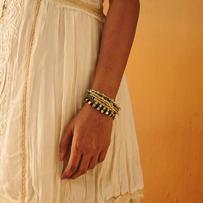 mujer con pulseras de verano doradas