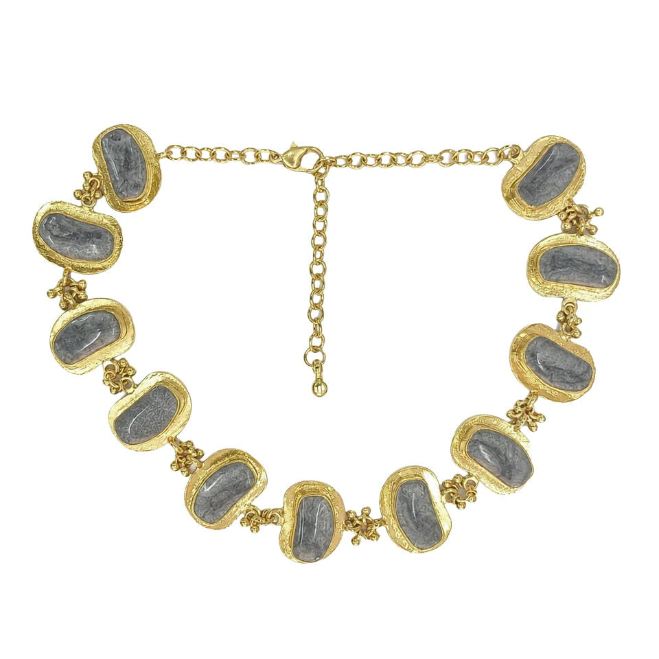 Collar Boat Stone Link de House of Tuhina, con piezas ovaladas grises, bordes dorados y cadena de extensión.