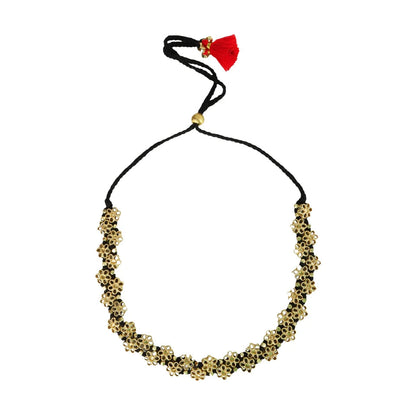 Collar Mishika dorado con flores de espejo, cordón negro ajustable y borla roja sobre fondo blanco.
