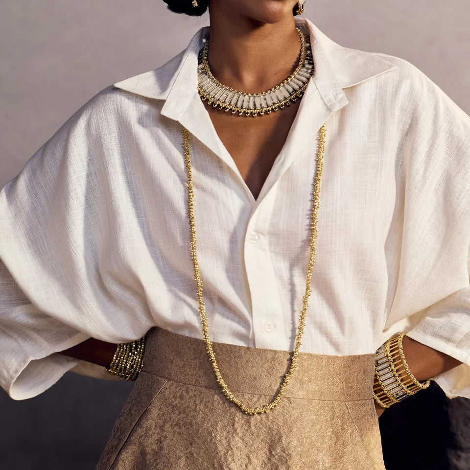 Modelo con el Collar Qabeela ivory de House of Tuhina, placas de esmalte enmarcadas en dorado, sobre camisa blanca