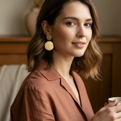 Aros Bianca con baño de oro de 18 quilates y diseño de doble disco satinado. Hechos en Brasil, elegantes, livianos y de 6 cm de largo.