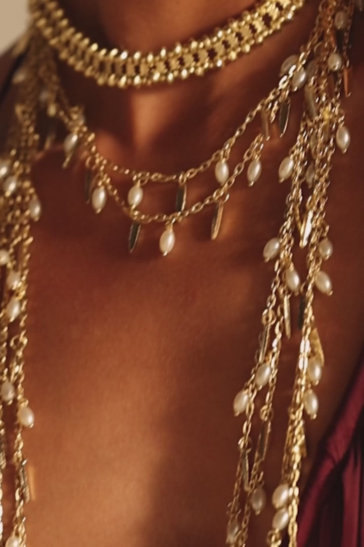 Video de Modelo con Collar Marina Dorado ajustado al cuello, combinado con collares largos y aros dorados