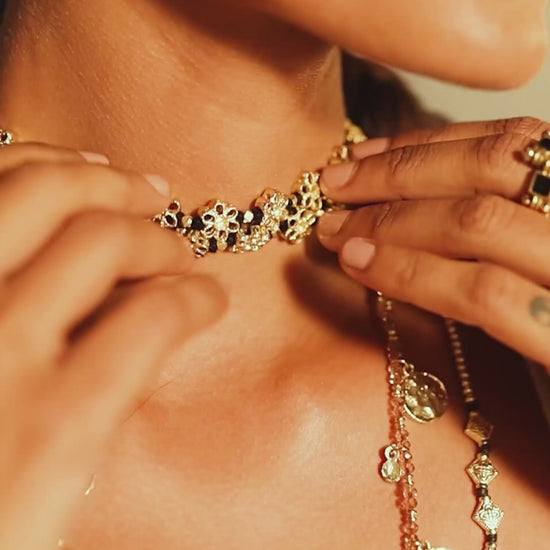 primer plano del Collar Mishika con flores doradas de espejo al cuello de una modelo