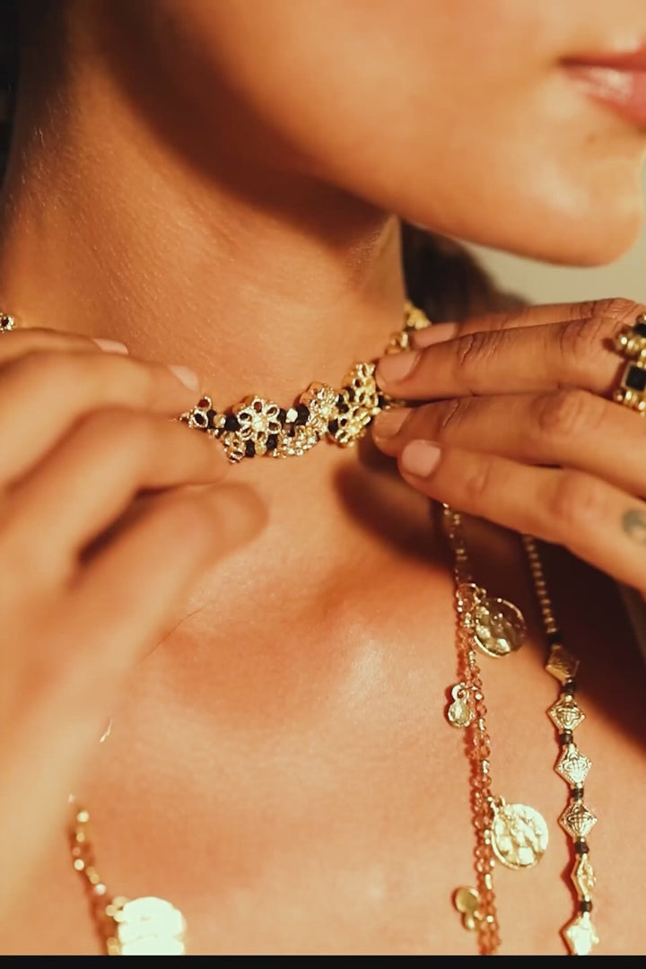 primer plano del Collar Mishika con flores doradas de espejo al cuello de una modelo