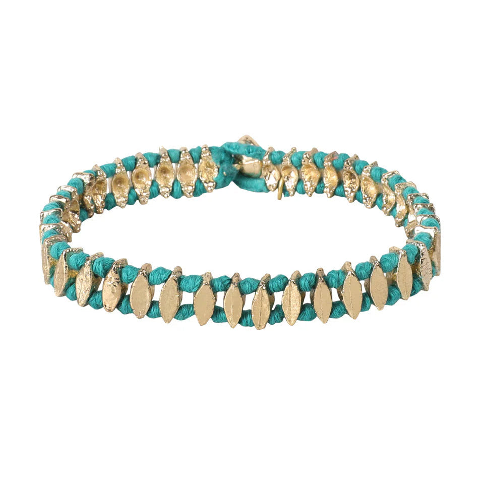 Pulsera Nabila Leaf de lujo artesanal con hojas metálicas doradas y tejido rojo, hecha a mano, diseño exclusivo de joyería semi lujo