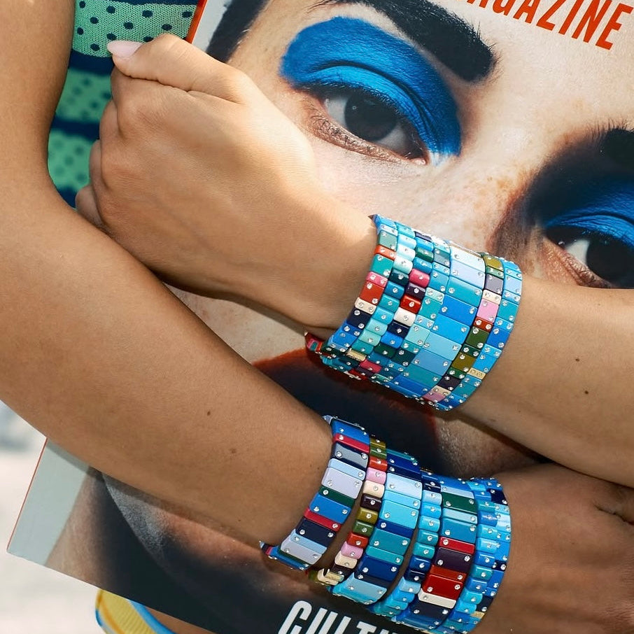 Mujer muestra pulseras Dominó apiladas en tonos azules
