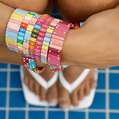 Mujer con pulseras Dominó apiladas de esmalte pintado y cristales